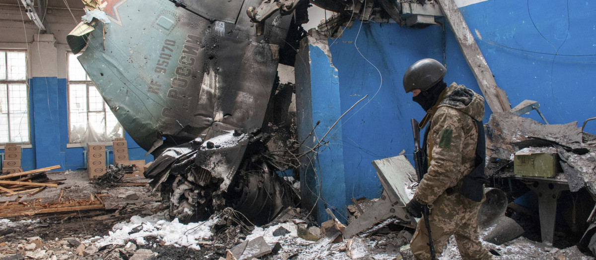 Un militar ucraniano camina más allá de la aleta de cola vertical de un bombardero ruso Su-34 ubicado en un edificio dañado en Járkov.