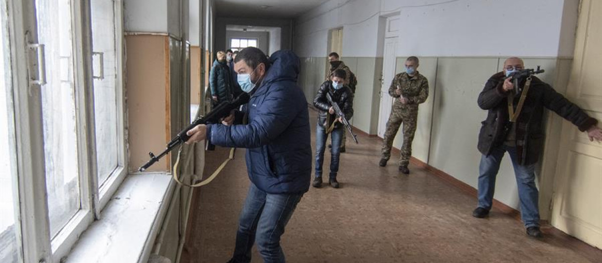 Activistas de Defensa Territorial y sus hijos asisten a un ejercicio militar por un caso de ataque en una escuela en Mariúpol, sureste de Ucrania