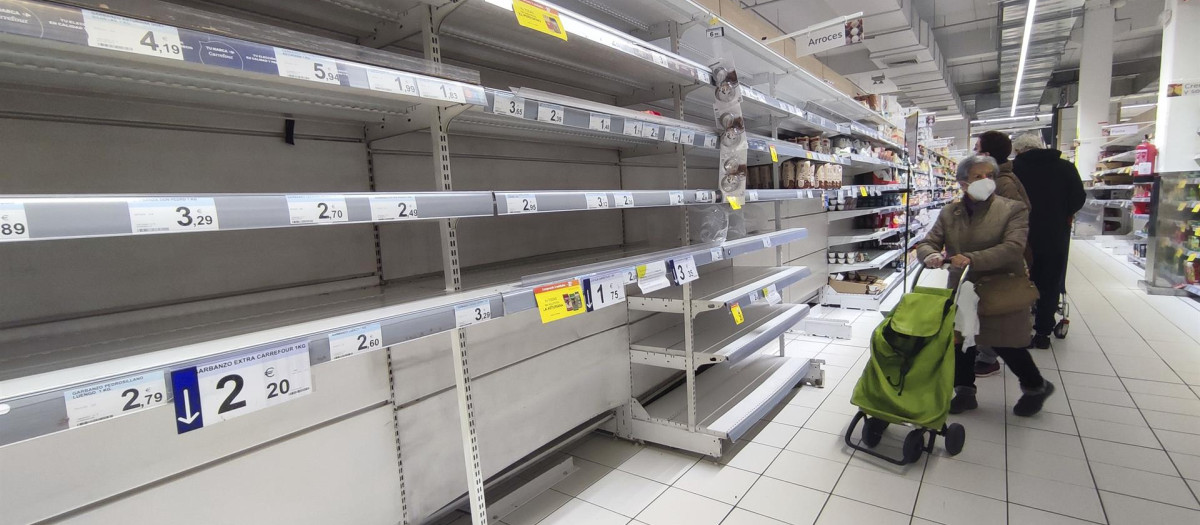 Una mujer observa unas estanterías vacías de legumbres en un supermercado de Madrid este miércoles