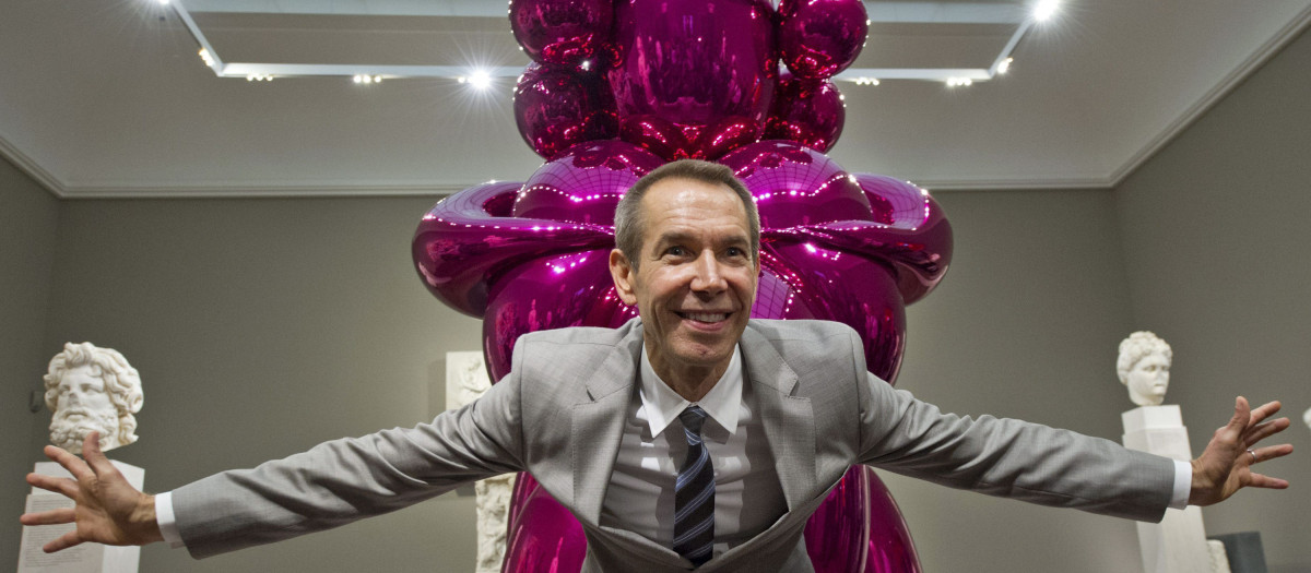 El artista estadounidense Jeff Koons mientras posa junto a su escultura "Balloon Venus"