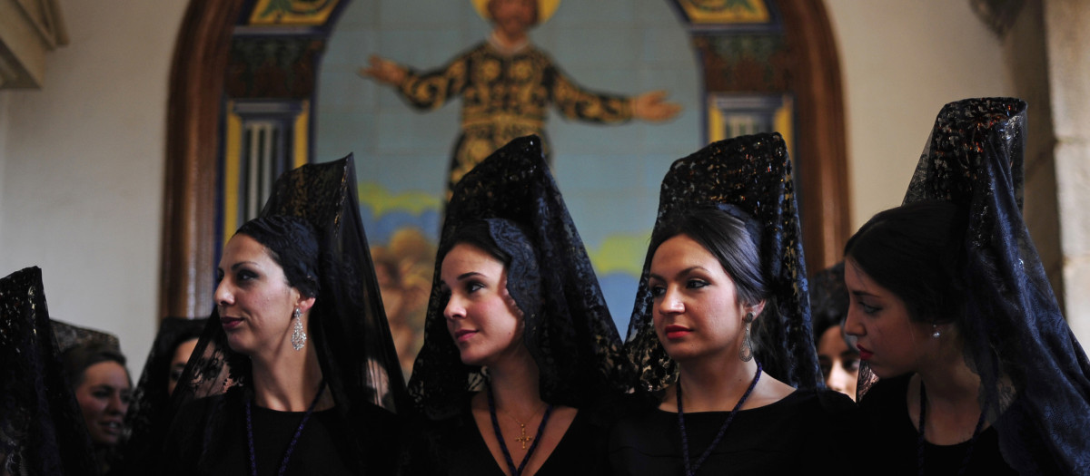 Women wearing the traditional mantilla from "Jesus Caido" brotherhood participate during a Holy Week procession in Cordoba, Spain, Thursday, April 2, 2015.