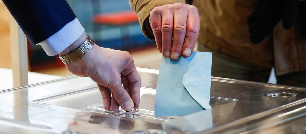 Un hombre deposita su voto en una urna durante la primera vuelta de las elecciones presidenciales de 2022 en Francia