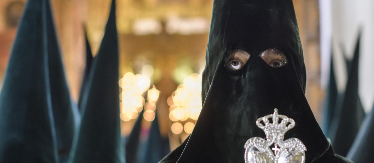 Un nazareno de la Macarena en la salida de la procesión