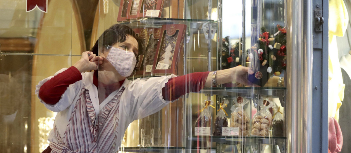 Una dependienta trabajando con una mascarilla, en una imagen de archivo