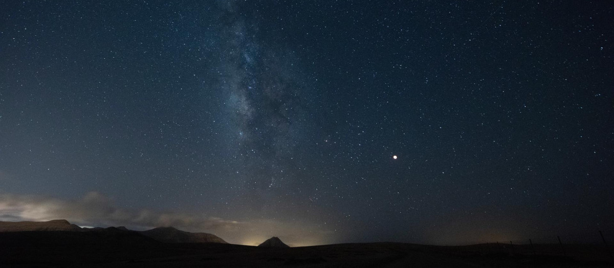 La Vía Láctea sobre la montaña de Tindaya, en Fuerteventura, durante el eclipse total de la Luna en la madrugada de este lunes