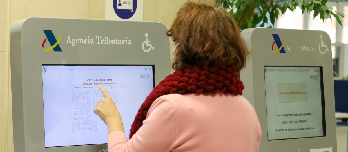 Una mujer recoge su turno en una oficina de la Agencia Tributaria.