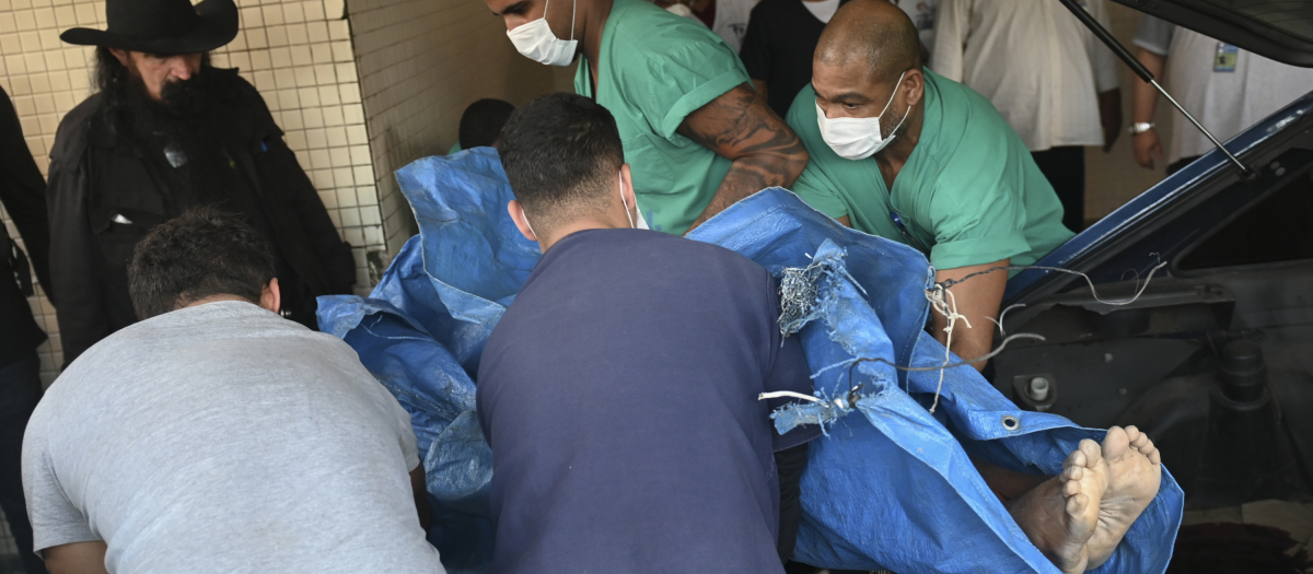 El cadáver de una víctima es trasladado de un automóvil a una camilla en el Hospital Getulio Vargas