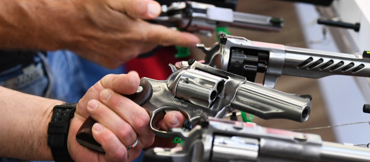 Attendees hold Ruger revolver pistols during the National Rifle Association (NRA) Annual Meeting at the George R. Brown Convention Center, in Houston, Texas on May 28, 2022. - America's powerful National Rifle Association kicked off a major convention in Houston Friday, days after the horrific massacre of children at a Texas elementary school, but a string of high-profile no-shows underscored deep unease at the timing of the gun lobby event. (Photo by Patrick T. FALLON / AFP)