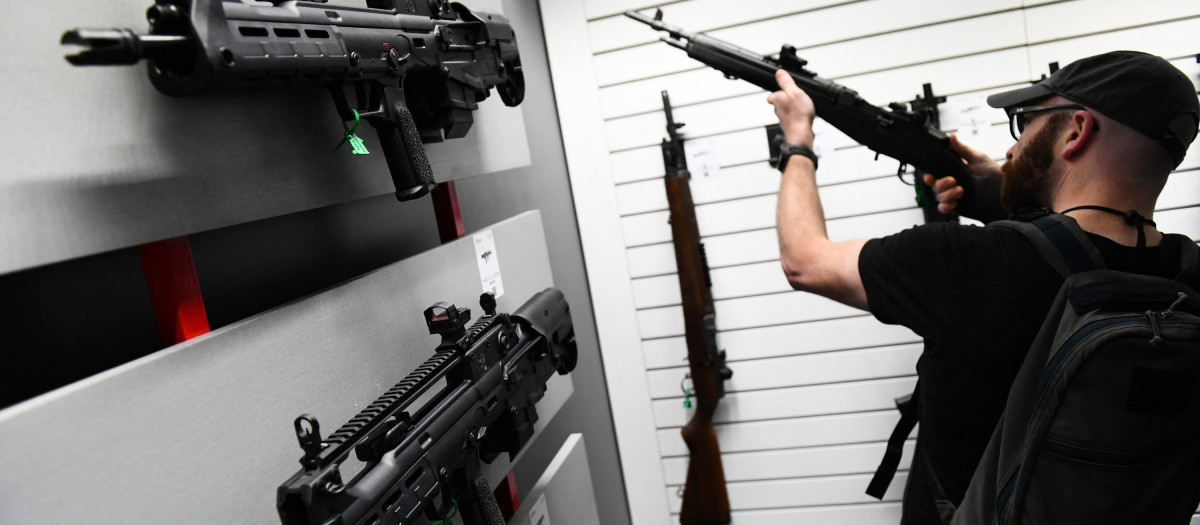 Springfield Armory Hellion bullpup rifles (L) are displayed as an attendee holds an M1A series rifle during the National Rifle Association (NRA) Annual Meeting at the George R. Brown Convention Center, in Houston, Texas on May 28, 2022. - America's powerful National Rifle Association kicked off a major convention in Houston Friday, days after the horrific massacre of children at a Texas elementary school, but a string of high-profile no-shows underscored deep unease at the timing of the gun lobby event. (Photo by Patrick T. FALLON / AFP)