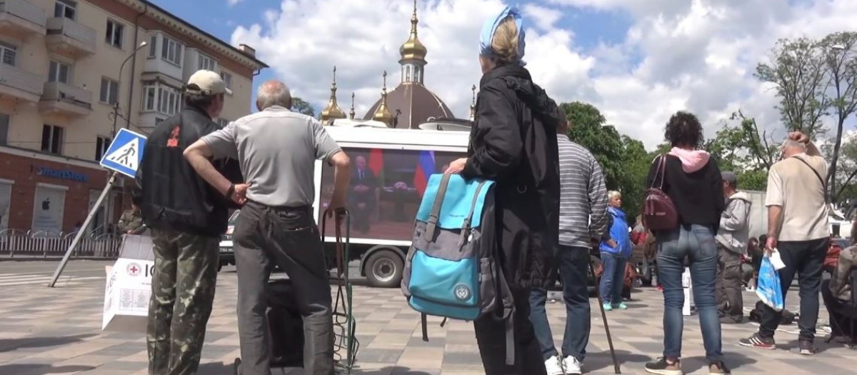 Residentes de Mariúpol observan un "camión pantalla" con propaganda rusa