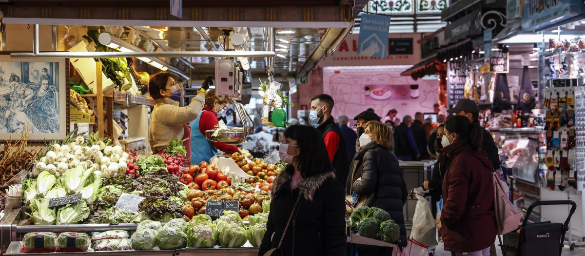 Varias personas compran en un puesto de fruta y verdura en el Mercado Central de Valencia, - Rober Solsona