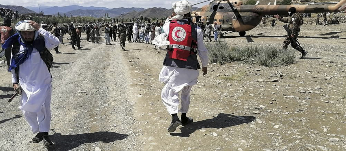 This photograph taken on June 22, 2022 and received as a courtesy of the Afghan government-run Bakhtar News Agency shows soldiers and Afghan Red Crescent Society officials near a helicopter at an earthquake hit area in Afghanistan's Gayan district, Paktika province. - A powerful earthquake struck a remote border region of Afghanistan overnight killing at least 920 people and injuring hundreds more, officials said on June 22, with the toll expected to rise as rescuers dig through collapsed dwellings. (Photo by Bakhtar News Agency / AFP) / XGTY / EDITORS NOTE --- RESTRICTED TO EDITORIAL USE - MANDATORY CREDIT "AFP PHOTO /Bakhtar News Agency " - NO MARKETING - NO ADVERTISING CAMPAIGNS - DISTRIBUTED AS A SERVICE TO CLIENTS - NO ARCHIVE