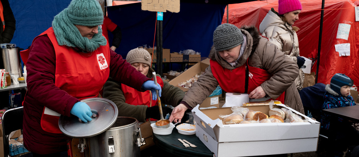 Volunteers from Caritas Poland serve hot soup for refugees on a camp in the commercial area fn Przemysl, southwestern Poland, on March 1, 2022.