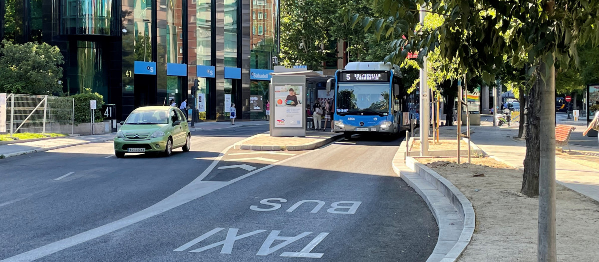 Vehículo y autobús de la EMT circulando por La Castellana