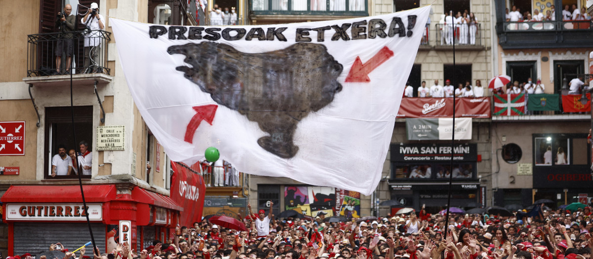 Vista de una bandera a favor del regreso al País Vasco de los presos de ETA tras el chupinazo en la Plaza Consistorial de Pamplona este miércoles dando comienzo a los Sanfermines 2022