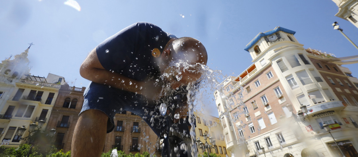 Un hombre se refresca para aliviar el calor en una fuente del centro de Córdoba