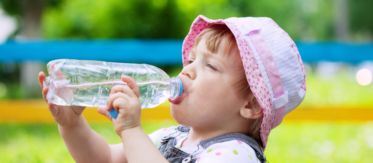 Niña de dos años en un parque hidratándose