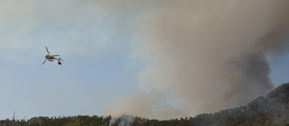 Vista de un helicóptero trabajando en las labores de extinción de en de Casas de Miravete, localidad que ha tenido que ser desalojada esta noche, y que evoluciona de forma "no favorable", según ha informado este viernes la Junta de Extremadura. La localidad de Casas de Miravete, próxima al Parque Nacional de Monfragüe, fue evacuada sobre las dos de la noche, ha indicado el 112.EFE/Eduardo Palomo