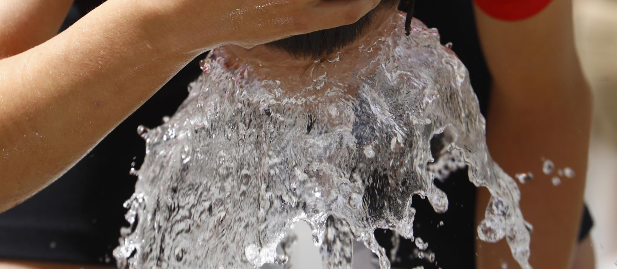 Un hombre se refresca en una de las fuentes de Córdoba