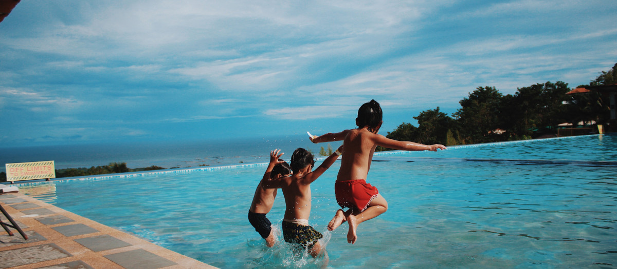 Niños tirándose a la piscina