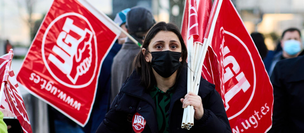 Una persona sosteniendo banderines de UGT.