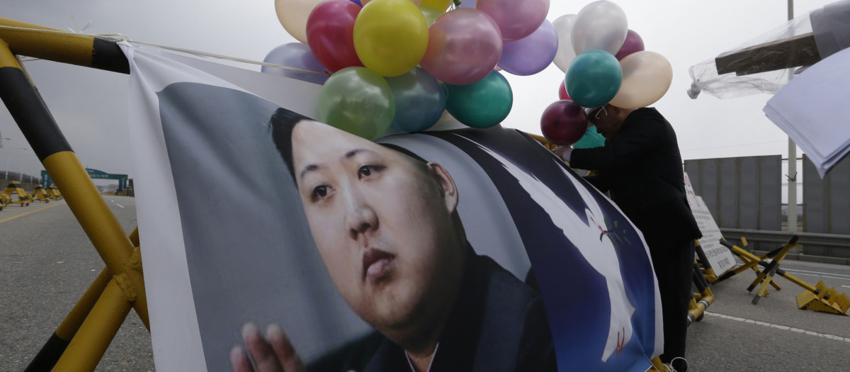 A South Korean protester attaches a picture of North Korean leader Kim Jong Un with balloons on a barricade during a rally demanding a regular operations of the Kaesong industrial complex near Unification Bridge near the border village of Panmunjom in Paju, north of Seoul, South Korea, Wednesday, April 10, 2013