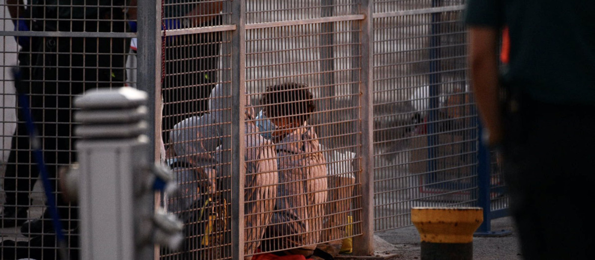 Dos migrantes son atendidos por la Guardia Civil y voluntarios de Cruz Roja en septiembre de 2021 en Ceuta