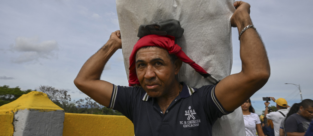 A Venezuelan man walks along the Simon Bolivar International Bridge as he returns to San Antonio del Tachira in Venezuela after buying goods in Cucuta, Colombia, on September 26, 2022, as the two countries reopen their land and air borders, completely closed since 2019. - Venezuela and Colombia will reopen their shared land border and resume commercial flights after renewing diplomatic ties severed in 2019. The countries reestablished formal ties on August 29 under the leadership of Venezuela's socialist president Nicolas Maduro and Colombia's new leftist leader, Gustavo Petro. (Photo by Yuri CORTEZ / AFP)