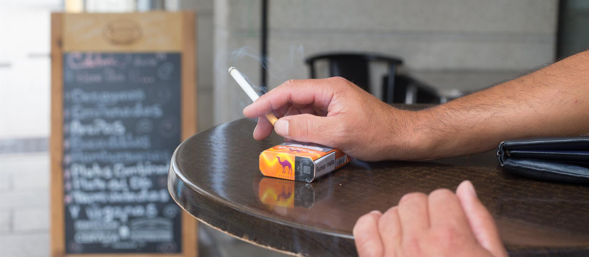 Una persona fuma en una terraza durante el primer día de la prohibición de realizarlo en la vía pública en Galicia si no existe una distancia de dos metros de separación con otras personas para evitar contagios de Covid-19