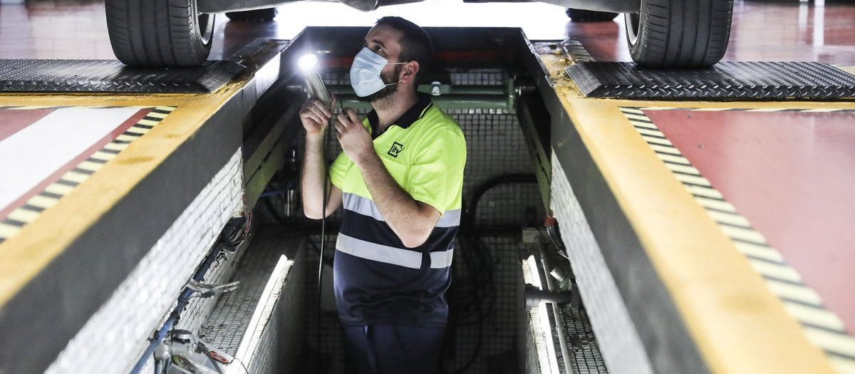Revisión de los bajos del automóvil en el foso del centro técnico