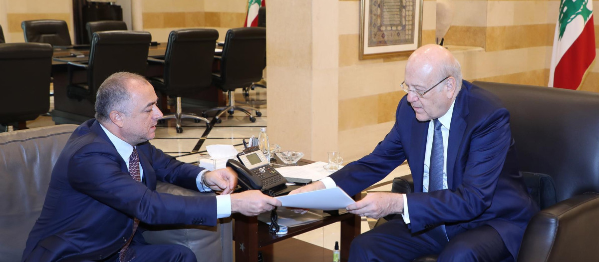 El primer ministro libanés Najib Mikati (D) recibe del vicepresidente del parlamento libanés y negociador Elias Bou Saab (Iz) la propuesta mediada por EE.UU. para demarcar la frontera marítima con Israel