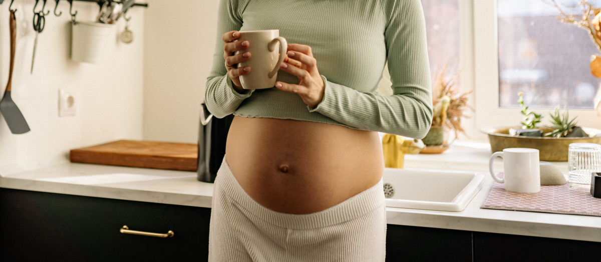 Una mujer embarazada con una taza de café