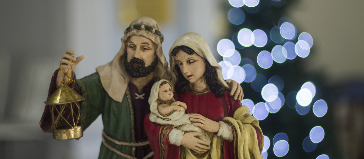 Un Misterio frente a un árbol de Navidad