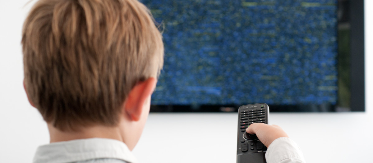 Un niño frente a un televisor