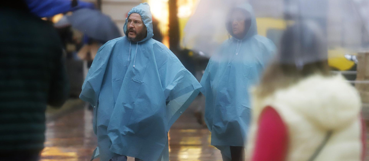 Varias personas se resguardan con paragua