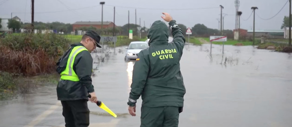 Dos Guardias civiles tratan de impedir que un Seat Ibiza quede atascado en una balsa de agua