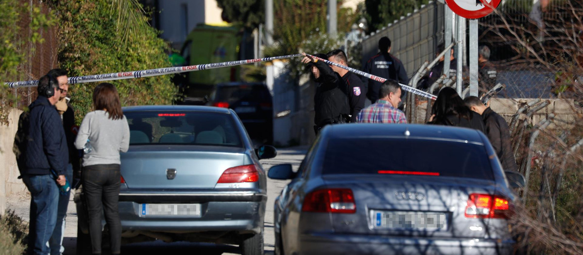 Un policía sostiene el precinto en las inmediaciones de la casa