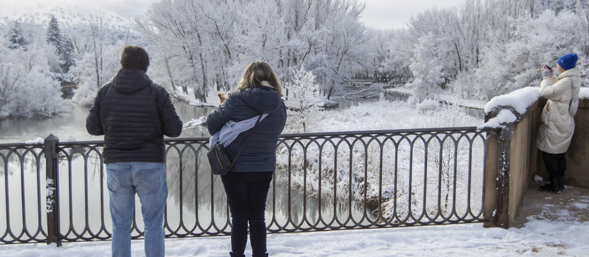 Turistas hacen fotos junto al río Duero, este viernes en Soria