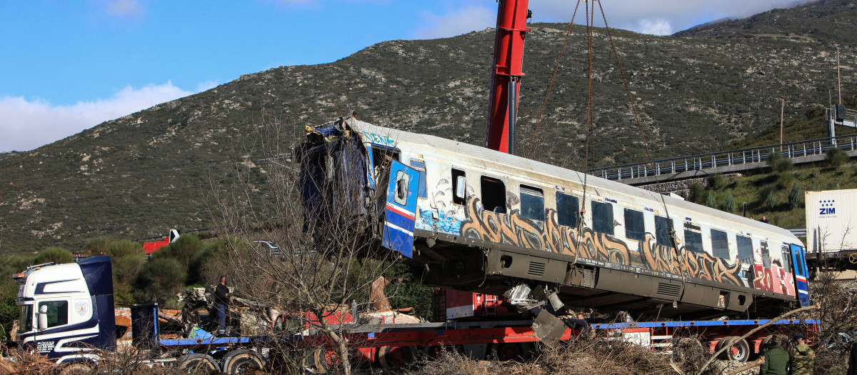 Operarios retiran un vagón de tren, en el valle de Tempi cerca de Larisa