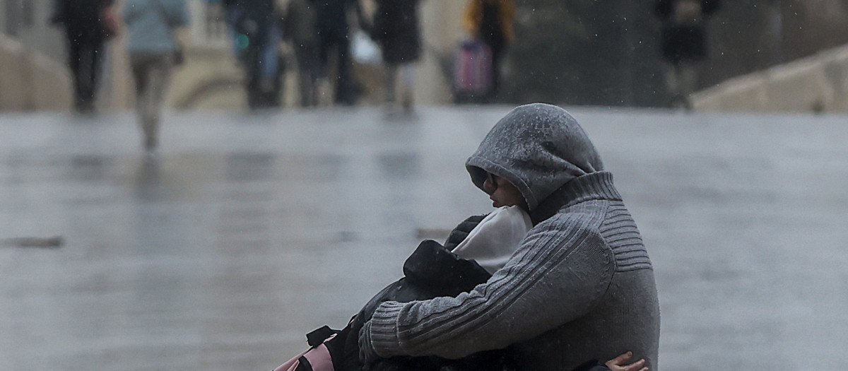 Dos personas se abrazan bajo la lluvia en Valencia