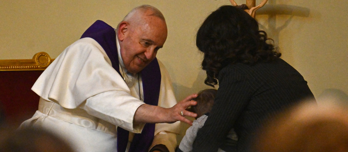 Pope Francis blesses a child as he hears a woman's confession, as he presides over the "24 Hours of the Lord" at the parish of Santa Maria delle Grazie al Trionfale, on March 17, 2023 in Rome. (Photo by Filippo MONTEFORTE / AFP)