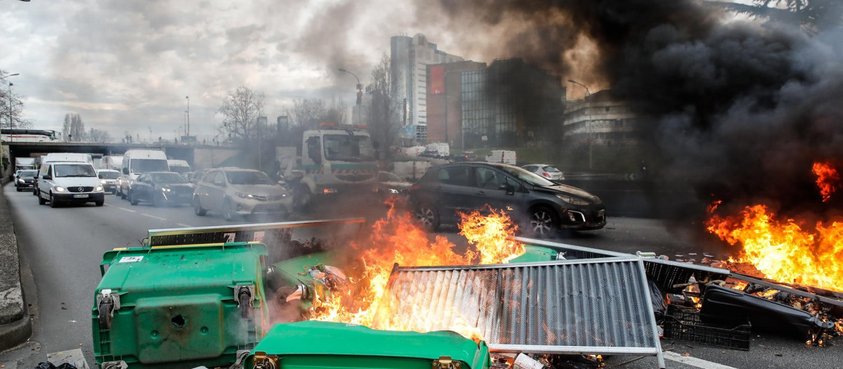 Arde una barricada mientras los manifestantes bloquean el tráfico en la avenida periférica de París en horas de la mañana para distribuir volantes contra la reforma de las pensiones del gobierno francés, en París.