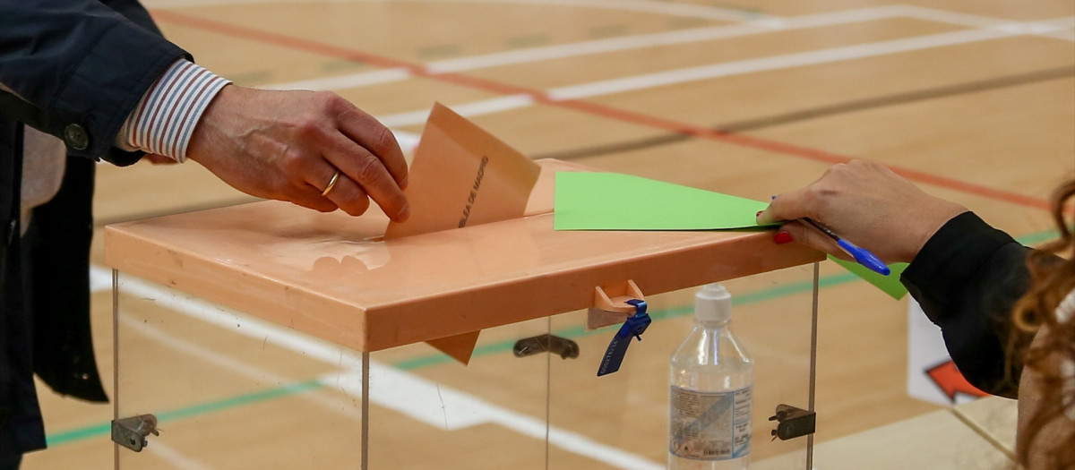 Un hombre ejerce su derecho a voto en el colegio durante la jornada electoral del 4 de mayo de 2021, en Madrid