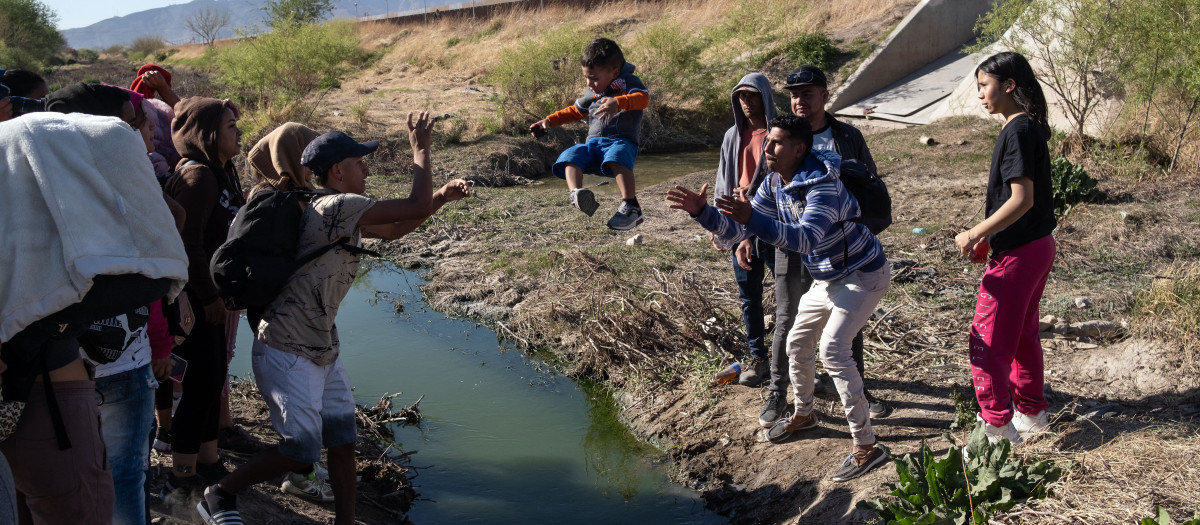 Migrants cross the Bravo river seen from the Mexican side of the US-Mexico border in Ciudad Juarez, Chihuahua state, Mexico, on March 29, 2023. - About 200,000 people try to cross the border from Mexico into the United States each month, most of them fleeing poverty and violence in Central and South America. (Photo by Guillermo Arias / AFP)