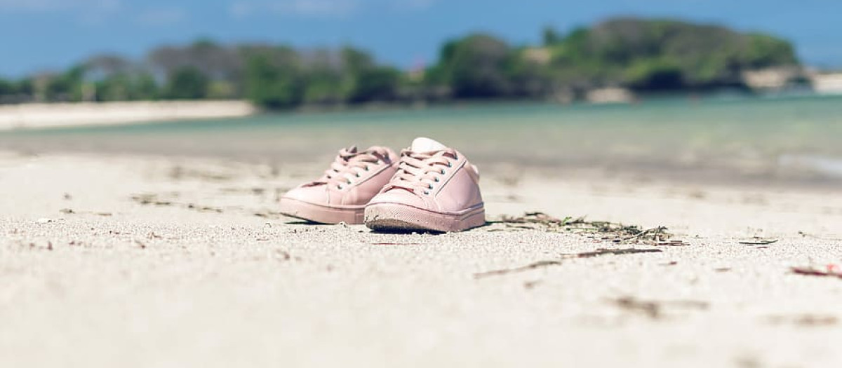 Un par de zapatillas en una playa