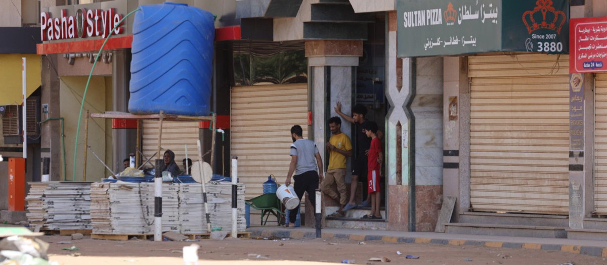 Los sudaneses se paran frente a una tienda en Jartum, Sudán