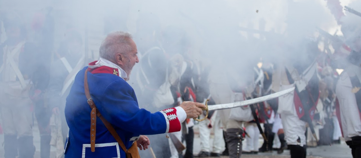 Un madrileño frente al fuego francés en la recreación del 2 de mayo de 1808 en la Plaza de Oriente