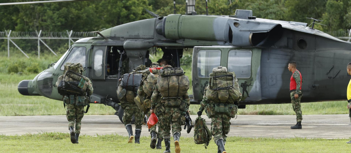 Los soldados abordan un helicóptero que se dirige a la zona de búsqueda de los menores perdidos en Colombia