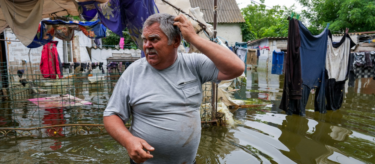 Un residente local camina por el patio inundado de su casa en Mykolayiv