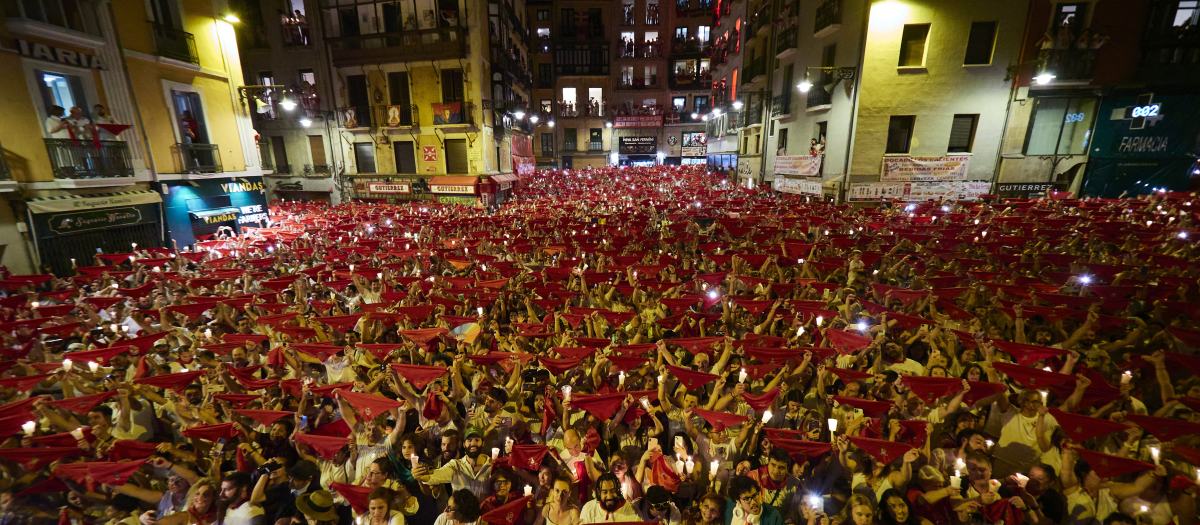 Un grupo de personas levantan sus pañuelos y sus velas durante el ‘Pobre de mí’ para decir adiós a las fiestas de San Fermín 2023